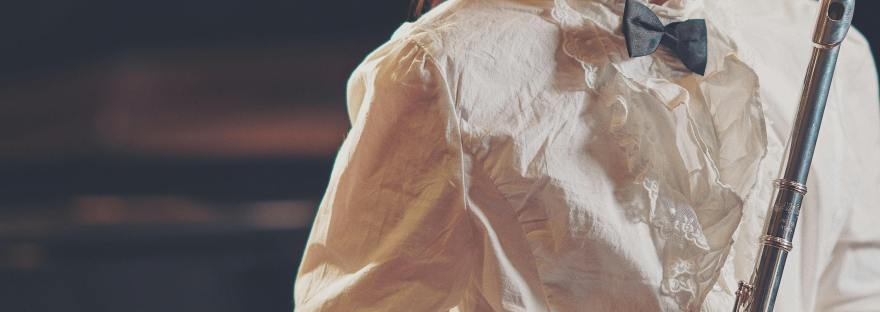 A young woman in a white shirt with a flute